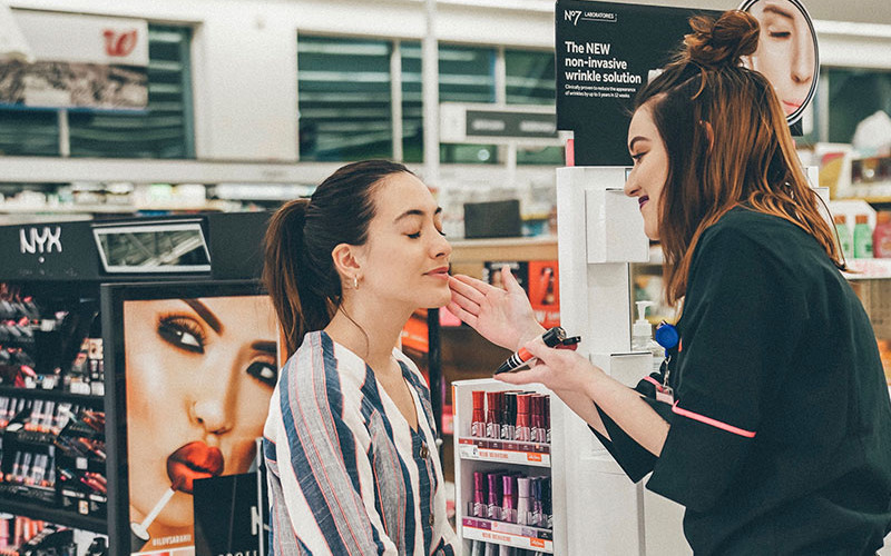 Woman applying makeup to another woman's face