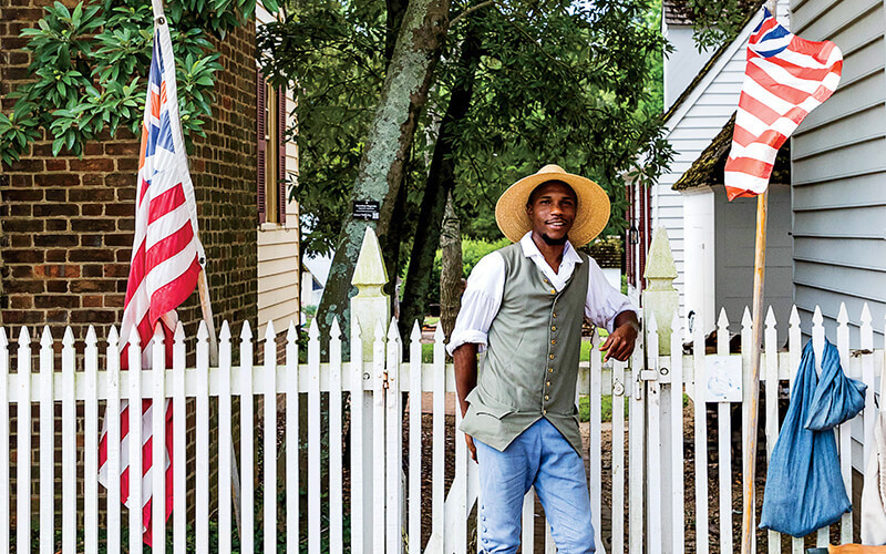 Man standing in front of the fence wearing period clothing