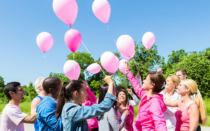People holding pink balloons
