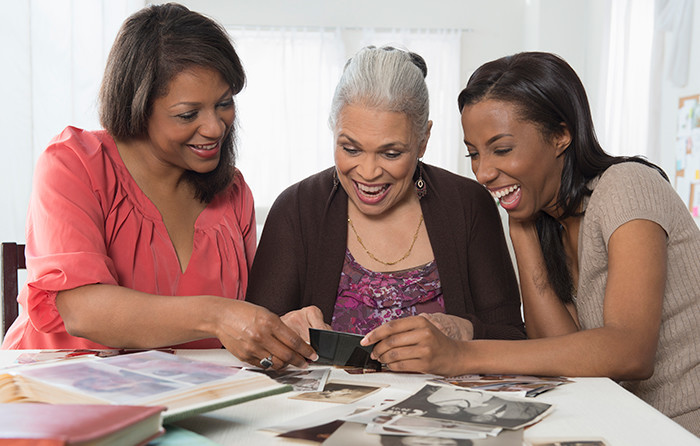 Generations of women looking at pictures and smiling