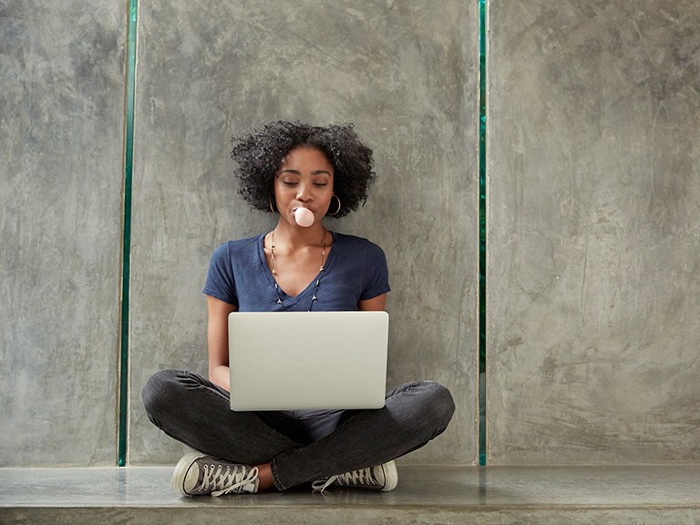 woman chewing gum on laptop