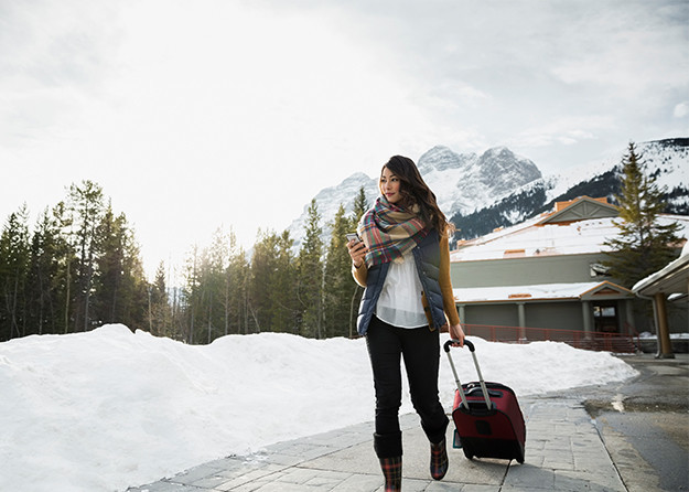 woman in snow with luggage